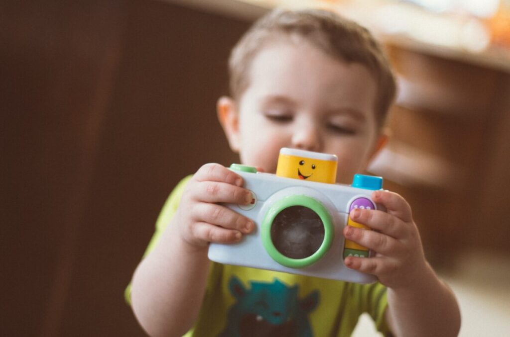 子供がおもちゃのカメラで遊んでいる